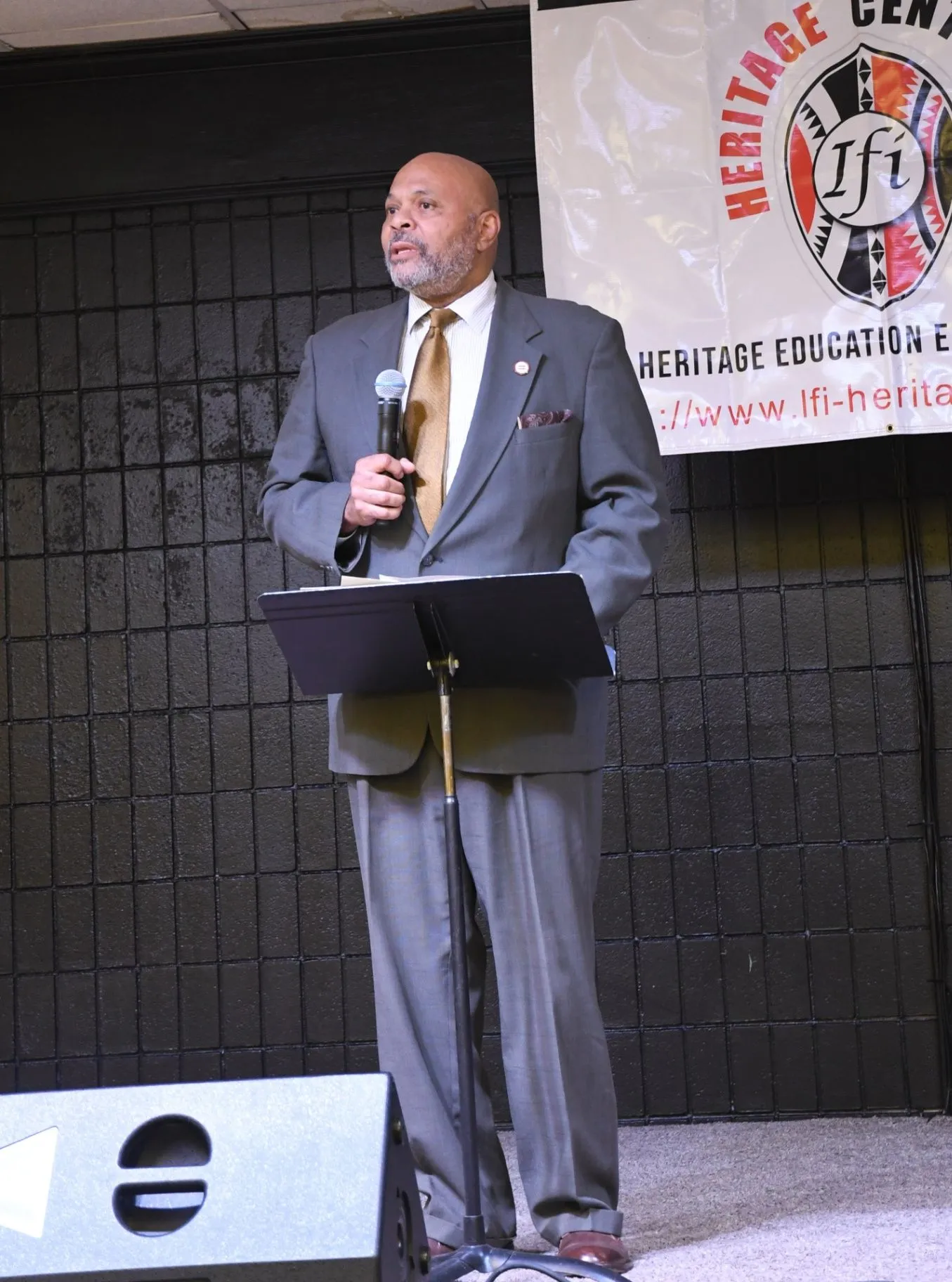 A speaker presents at an Ifi Heritage Center event from behind a lectern.
