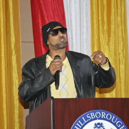 A speaker holds a microphone at a Hillsborough County podium.